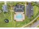 Overhead view of a community pool featuring a unique shape, seating, a parking lot, and landscaping at 5660 Keaton Springs Dr, Lakeland, FL 33811