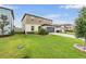 Well-maintained two-story home with a gray two-car garage, lush lawn, and colorful landscaping at 5660 Keaton Springs Dr, Lakeland, FL 33811