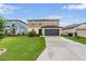 Inviting two-story home featuring manicured lawn, tidy landscaping, and a two-car garage at 5660 Keaton Springs Dr, Lakeland, FL 33811