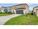 Charming two-story home with well-manicured lawn and a gray two-car garage in a well-kept neighborhood at 5660 Keaton Springs Dr, Lakeland, FL 33811