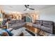 Open-concept living room features hardwood floors, ceiling fan and comfortable brown leather sofas at 5660 Keaton Springs Dr, Lakeland, FL 33811