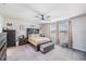Bright main bedroom features neutral decor, ceiling fan, and large windows at 5660 Keaton Springs Dr, Lakeland, FL 33811