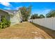 View of the side yard with a privacy fence, lawn and the exterior of the house at 6143 Black Walnut Dr, Bartow, FL 33830