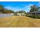 Large grassy backyard with a fence, shed, and screened-in pool area at 6143 Black Walnut Dr, Bartow, FL 33830