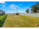Spacious backyard featuring a well-maintained lawn, storage shed, and privacy fence under a bright blue sky at 6143 Black Walnut Dr, Bartow, FL 33830