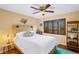 Cozy bedroom with a ceiling fan, natural light, and a comfortable bed with decorative pillows at 6143 Black Walnut Dr, Bartow, FL 33830