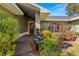Inviting front entrance with a red door, brick pathway, and lush, tropical landscaping at 6143 Black Walnut Dr, Bartow, FL 33830