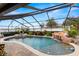 Screened-in pool with rock waterfall feature, spa, and surrounding patio area at 6143 Black Walnut Dr, Bartow, FL 33830
