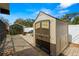 Close-up of the storage shed with double doors, sitting on a brick-paved area with a view of the pool at 6143 Black Walnut Dr, Bartow, FL 33830