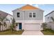 Charming two-story home with a two-car garage, light blue paint, and a beautifully landscaped yard at 770 Ambleside Dr, Haines City, FL 33844