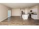 Spacious open-concept living space featuring wood floors, kitchen island, and sliding glass door to the backyard at 770 Ambleside Dr, Haines City, FL 33844