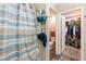 Bathroom with blue and tan shower curtain, towels, and a large walk-in closet at 1368 Axel Cir, Winter Haven, FL 33880