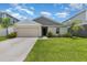 Charming single-story home with well-maintained lawn, two-car garage, and lovely landscaping at 1368 Axel Cir, Winter Haven, FL 33880