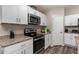 Well-equipped kitchen featuring stainless steel appliances, granite countertops and white cabinetry at 1368 Axel Cir, Winter Haven, FL 33880