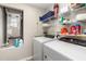 Bright laundry room with modern washer, dryer, and ample shelving for storage at 1368 Axel Cir, Winter Haven, FL 33880