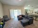 Open-concept living room with a gray sectional sofa and access to the dining area at 1368 Axel Cir, Winter Haven, FL 33880