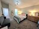 Cozy bedroom with plush carpeting, neutral walls, a queen bed, and a view into the en suite bathroom at 1368 Axel Cir, Winter Haven, FL 33880