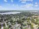 Aerial view of a lakeside community featuring tree-lined streets and houses, all under a sunny sky at 229 Temple Ave, Fern Park, FL 32730
