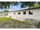 Back yard featuring a small patio area with white support columns and three large windows on the house at 229 Temple Ave, Fern Park, FL 32730