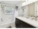 Bright bathroom featuring double sinks, a large mirror, and a shower-tub combination with white tiles at 229 Temple Ave, Fern Park, FL 32730