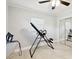 A bedroom shows a ceiling fan, white walls, tiled floors, a window, and an inversion table at 229 Temple Ave, Fern Park, FL 32730