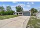 Wide concrete driveway leading up to a charming one-story house featuring a two-car garage with matching light blue doors at 229 Temple Ave, Fern Park, FL 32730