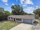Charming single-story home with a well-manicured front yard, grey trim, and large driveway at 229 Temple Ave, Fern Park, FL 32730