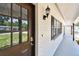 Inviting front entryway with a decorative glass door and a sleek, covered walkway with a view of the landscaped yard at 229 Temple Ave, Fern Park, FL 32730