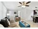 Open-concept living area with tile flooring, a gray sofa set, and a view of the modern kitchen with stainless steel appliances at 229 Temple Ave, Fern Park, FL 32730