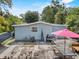 Back of house features patio area with grill, weights and covered seating, ideal for relaxation and entertainment at 306 Avenue A E, Winter Haven, FL 33880