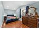 Charming bedroom features wood floors, dresser, mirror and blue-painted walls at 306 Avenue A E, Winter Haven, FL 33880