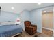 Comfortable bedroom boasts a queen bed, plush armchair, and access to a private bathroom at 306 Avenue A E, Winter Haven, FL 33880
