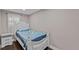 Cozy bedroom features a twin bed, bedside table, and window with natural light at 306 Avenue A E, Winter Haven, FL 33880