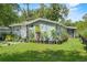Charming single-story home with well-manicured lawn and adorned with numerous potted plants and decorations at 306 Avenue A E, Winter Haven, FL 33880