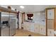 Traditional kitchen features stainless steel refrigerator and white cabinets with laminate countertop at 306 Avenue A E, Winter Haven, FL 33880