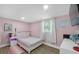 Cozy bedroom featuring a comfortable bed, natural light, and a calm, pink-toned interior at 306 Avenue A E, Winter Haven, FL 33880