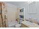Functional bathroom with a shower-tub combo, white tiled walls, and a vanity with storage at 4003 Prairie Bend Ln, Lakeland, FL 33812