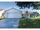 Charming single-story home featuring a well-manicured lawn and an attached two-car garage at 647 San Pedro Dr, Lady Lake, FL 32159