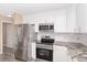 Modern kitchen featuring stainless steel appliances, white cabinets, and granite countertops at 647 San Pedro Dr, Lady Lake, FL 32159