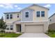Charming two-story home featuring a light beige exterior with a two car garage at 1221 Tidal St, Haines City, FL 33844