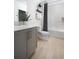 Clean bathroom featuring a gray vanity, white countertops, and a shower-tub combination with a patterned curtain at 1233 Tidal St, Haines City, FL 33844
