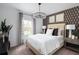 Comfortable bedroom with a patterned accent wall, soft bedding, and a view of the outdoors at 1233 Tidal St, Haines City, FL 33844