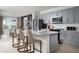 Modern kitchen with gray cabinets, stainless steel appliances and a white quartz island with bar seating at 1233 Tidal St, Haines City, FL 33844