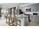 Modern kitchen with gray cabinets, stainless steel appliances and a white quartz island with bar seating at 1233 Tidal St, Haines City, FL 33844