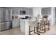 Modern kitchen featuring gray cabinets, stainless steel appliances, and a white quartz island with bar seating at 1233 Tidal St, Haines City, FL 33844