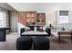 Relaxing living room featuring a black sofa, stylish decor, and a modern geometric painted accent wall at 1233 Tidal St, Haines City, FL 33844