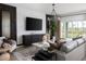 Modern living room featuring stylish furniture, sleek entertainment center, and sliding glass doors to the backyard at 1233 Tidal St, Haines City, FL 33844