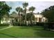 Enjoy the lush, green lawn and landscaping surrounding the community clubhouse, framed by stately palm trees and manicured shrubs at 2572 Robert Trent Jones Dr # 1235, Orlando, FL 32835