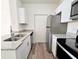 Well-lit kitchen features stainless steel appliances, granite countertops, and modern white cabinetry at 2572 Robert Trent Jones Dr # 1235, Orlando, FL 32835