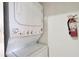 An efficient stacked washer and dryer unit, designed to save space, sits against a clean white wall at 2572 Robert Trent Jones Dr # 1235, Orlando, FL 32835